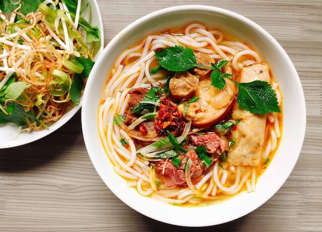 muestra un plato con sopa de spaguetis y su precio de $15